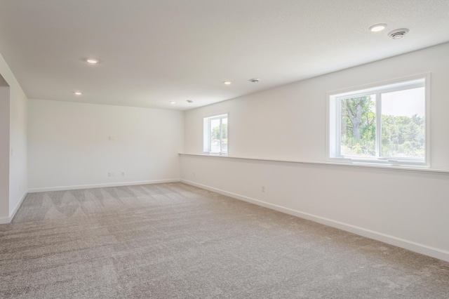 spare room featuring light colored carpet and a wealth of natural light