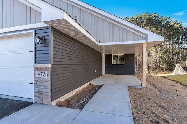 property entrance with a garage and a carport