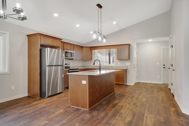 kitchen with sink, vaulted ceiling, a kitchen island, stainless steel appliances, and light stone countertops