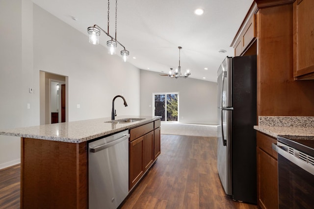 kitchen featuring dark wood-type flooring, sink, pendant lighting, stainless steel appliances, and a kitchen island with sink