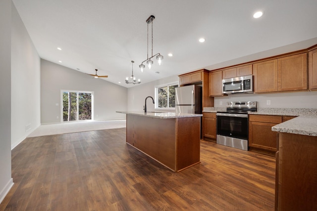 kitchen with pendant lighting, a healthy amount of sunlight, stainless steel appliances, and a center island with sink