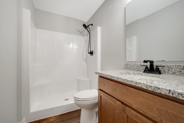 bathroom with vanity, hardwood / wood-style flooring, a shower, and toilet