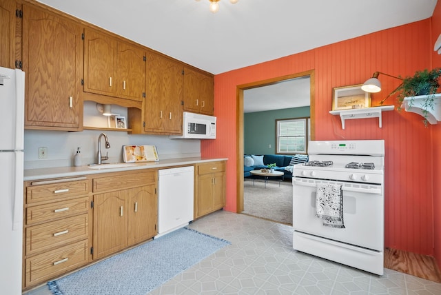 kitchen with a sink, white appliances, light floors, open shelves, and light countertops