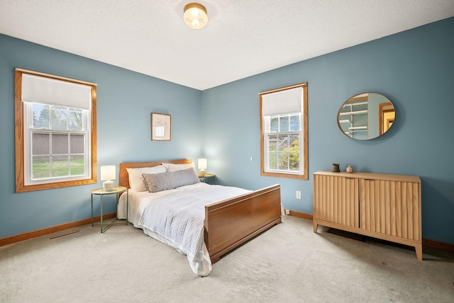 carpeted bedroom with baseboards, multiple windows, and visible vents