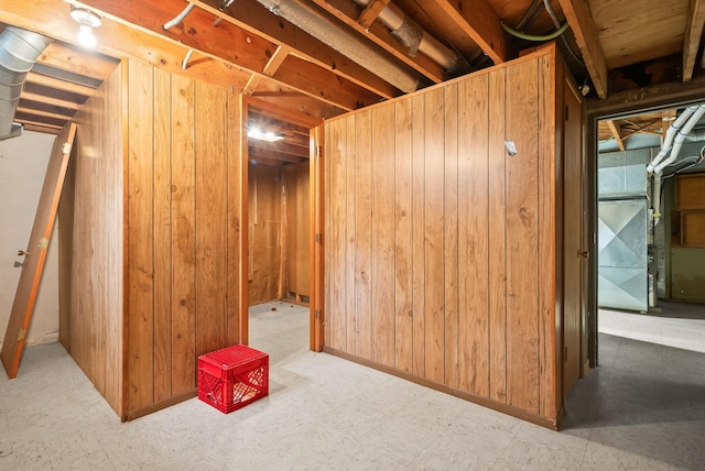 unfinished below grade area with tile patterned floors and wood walls