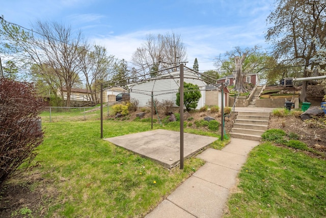 exterior space with fence, a lawn, and stairs