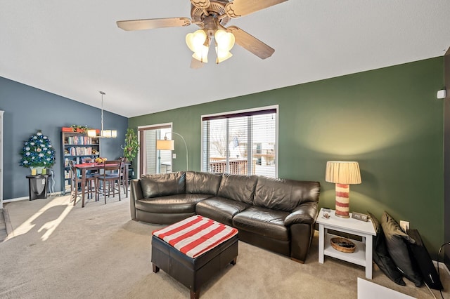 living room with ceiling fan, lofted ceiling, and light carpet