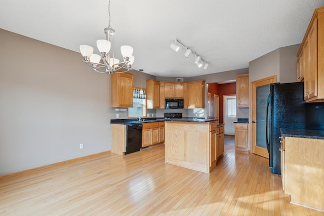 kitchen featuring a center island, black appliances, hanging light fixtures, light hardwood / wood-style flooring, and a notable chandelier