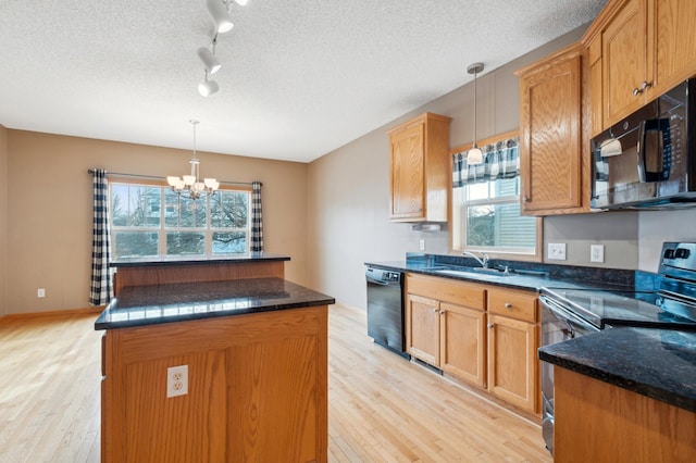 kitchen with sink, black appliances, pendant lighting, light hardwood / wood-style floors, and a kitchen island