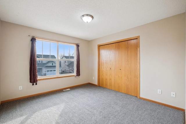 unfurnished bedroom featuring carpet flooring, a closet, and a textured ceiling