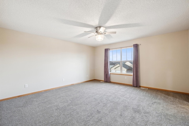 carpeted spare room with ceiling fan and a textured ceiling