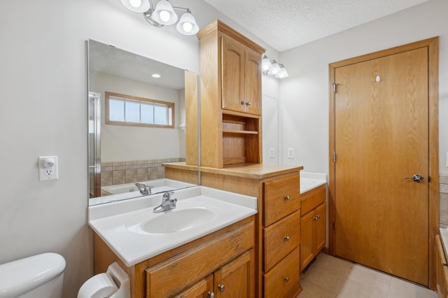 full bathroom featuring tile patterned flooring, separate shower and tub, a textured ceiling, toilet, and vanity