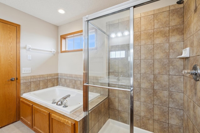 bathroom featuring a textured ceiling and independent shower and bath