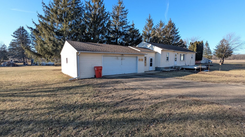 view of property exterior with a garage and a lawn