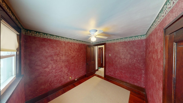 empty room with dark hardwood / wood-style flooring and ceiling fan