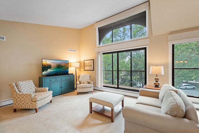 carpeted living room with a high ceiling and a baseboard heating unit