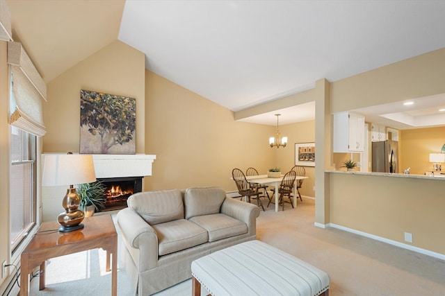 carpeted living room with a fireplace and a chandelier