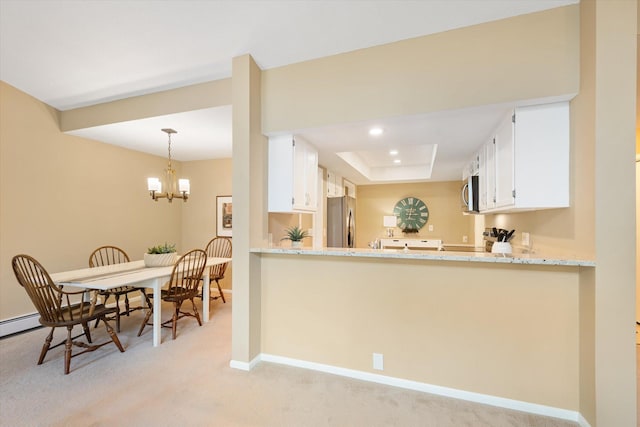 kitchen featuring light carpet, stainless steel appliances, white cabinetry, and light stone countertops