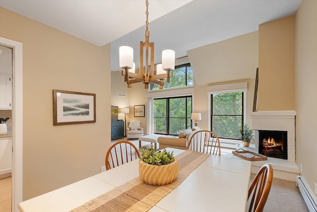 dining space featuring a notable chandelier, a fireplace, baseboard heating, and a high ceiling