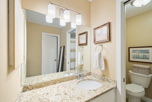 bathroom featuring vanity, a textured ceiling, and toilet