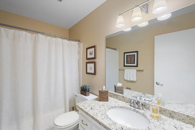 bathroom featuring a textured ceiling, vanity, and toilet