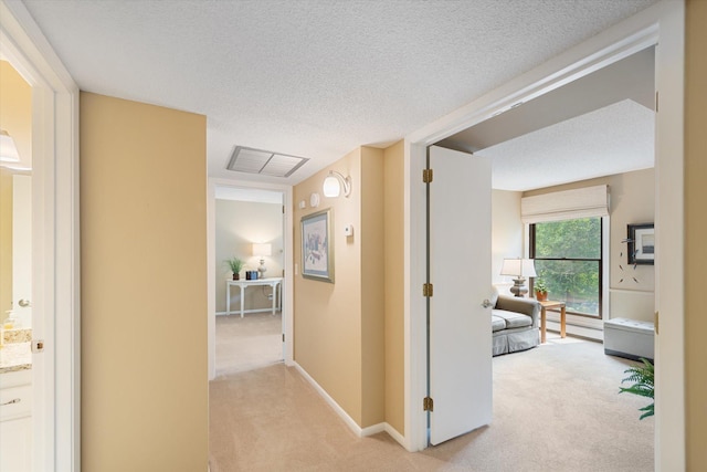 corridor featuring a textured ceiling, baseboard heating, and light carpet