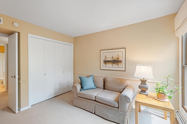 sitting room with baseboard heating and light carpet