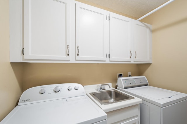 laundry room featuring cabinets, independent washer and dryer, and sink