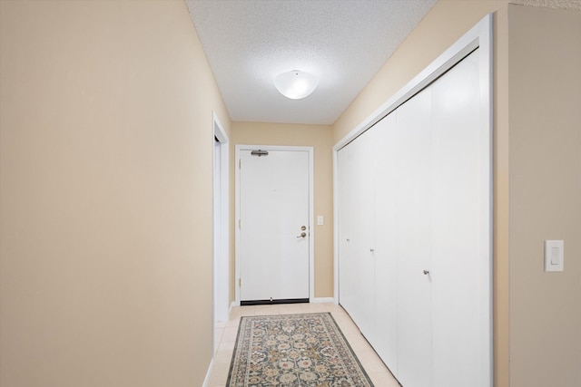 entryway featuring light tile patterned floors and a textured ceiling