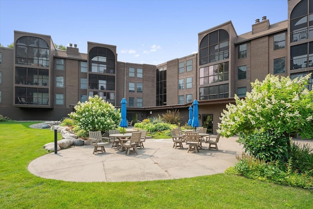 view of community featuring a lawn and a patio area