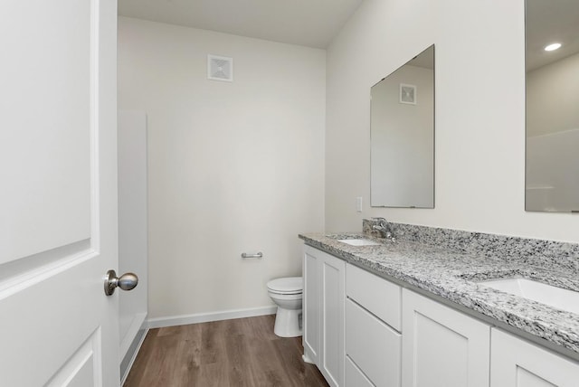 bathroom featuring vanity, hardwood / wood-style flooring, and toilet