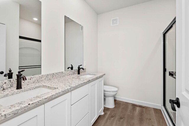 451 Wildflower Ln, Waverly, MN 55390 - bathroom featuring wood finished floors, double vanity, and a shower stall
