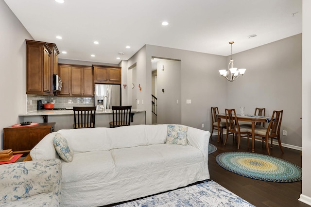 living room with dark hardwood / wood-style floors and a chandelier