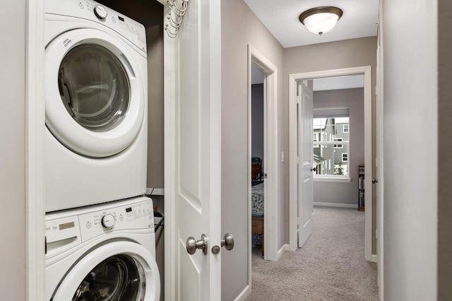 washroom featuring light carpet and stacked washer and clothes dryer