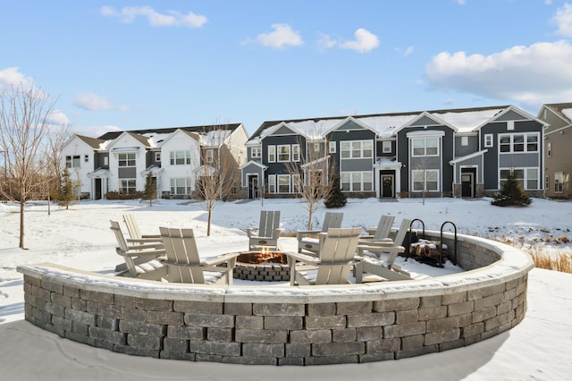 snow covered patio with an outdoor fire pit