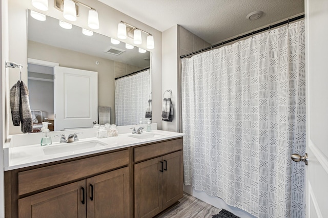 14592 Twin Lakes Cir, Burnsville, MN 55306 - bathroom with visible vents, wood finished floors, a sink, and double vanity
