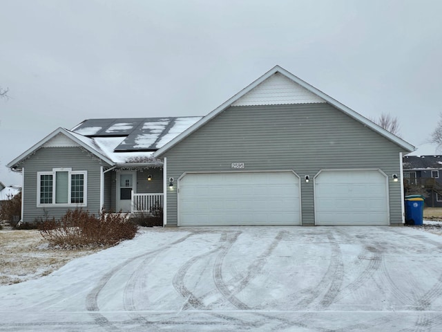 single story home with solar panels and a garage