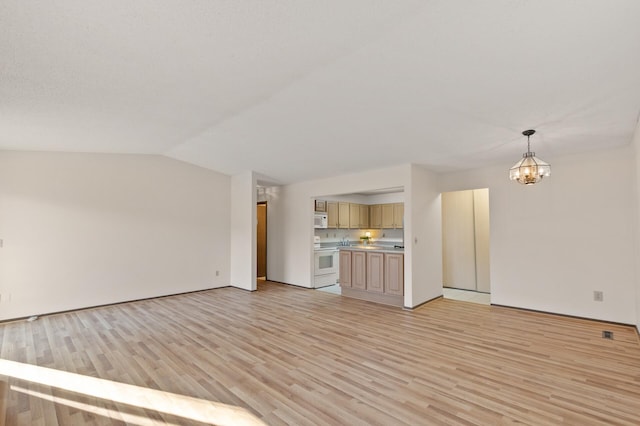 unfurnished living room with a notable chandelier, lofted ceiling, and light hardwood / wood-style flooring