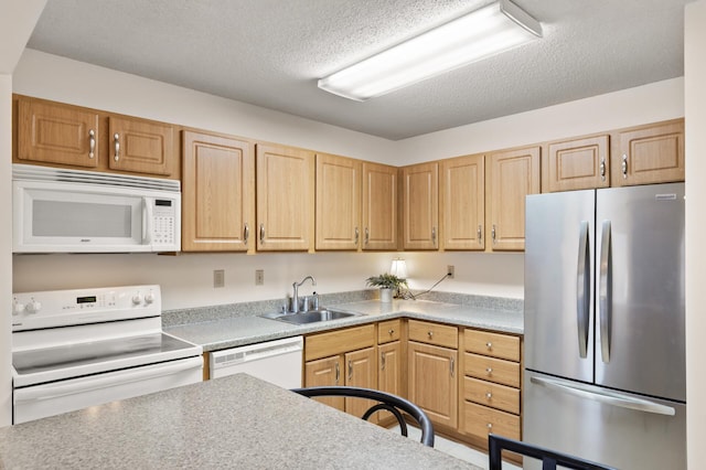 kitchen featuring a textured ceiling, white appliances, and sink