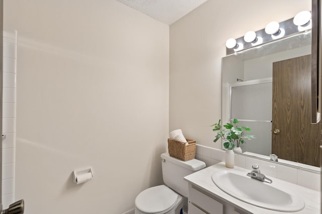 bathroom with vanity, a shower with shower door, a textured ceiling, and toilet