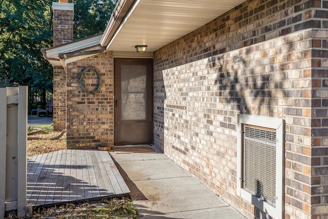 property entrance with heating unit and a wooden deck