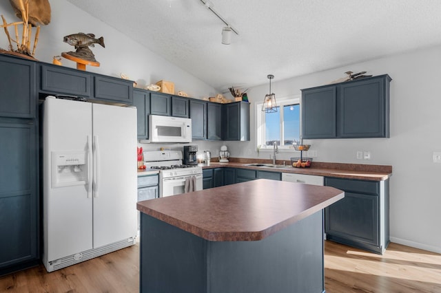 kitchen with pendant lighting, sink, white appliances, light hardwood / wood-style floors, and a textured ceiling