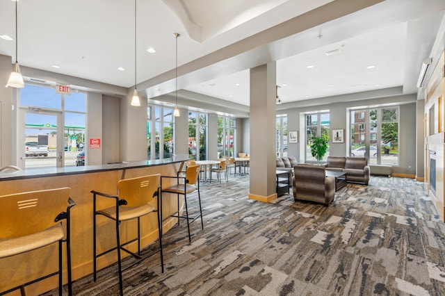 interior space featuring pendant lighting, a breakfast bar, and carpet floors