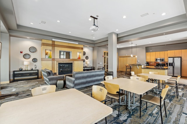 carpeted dining room with a tray ceiling