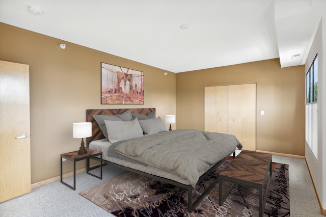 carpeted bedroom with a closet, visible vents, and baseboards