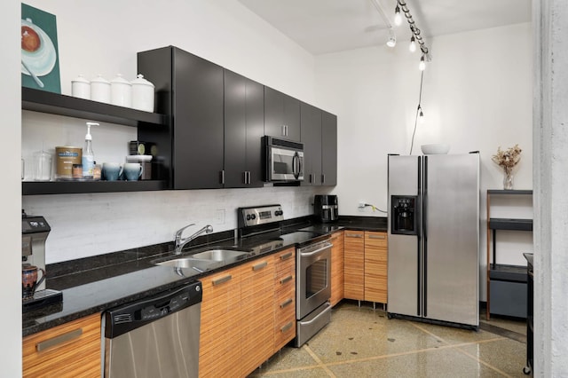 kitchen with decorative backsplash, stainless steel appliances, dark stone counters, and sink