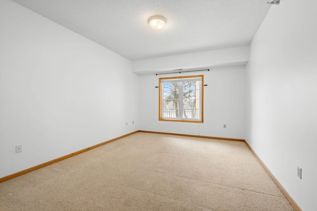 carpeted spare room featuring a textured ceiling