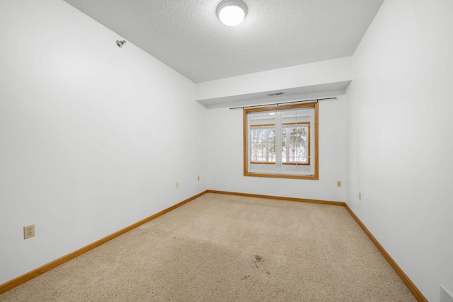 spare room featuring carpet floors and a textured ceiling