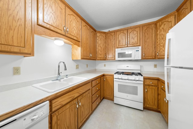 kitchen with white appliances, sink, and a textured ceiling