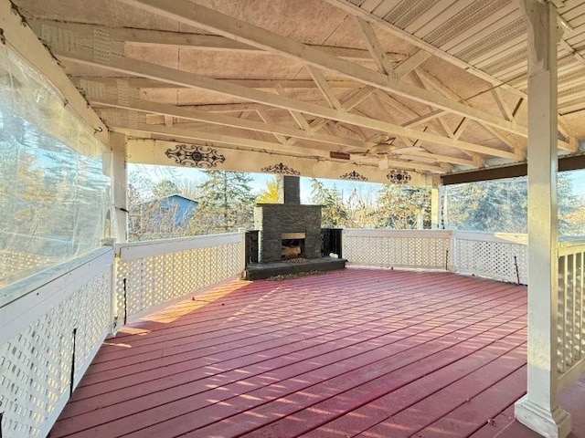 wooden deck with an outdoor stone fireplace